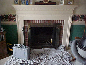 Fireplace being prepped with drop cloth and equipment for video inspection of chimney