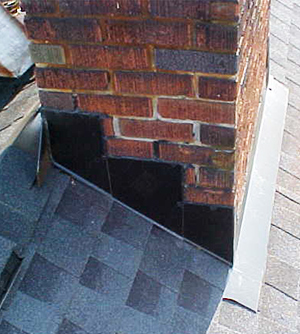 Close up of repaired black chimney flashing on brick chimney