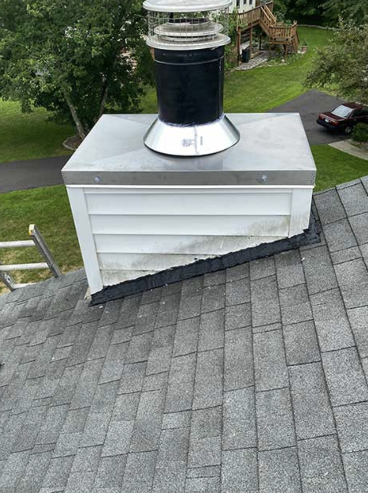 White vinyl sided chimney with stainless steel chase cover and chimney cap