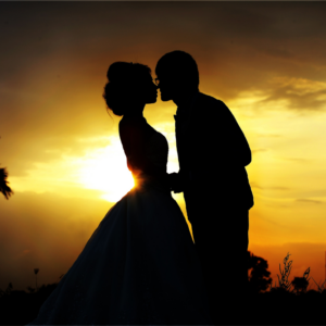 a silhouette of a couple against a yellow sky